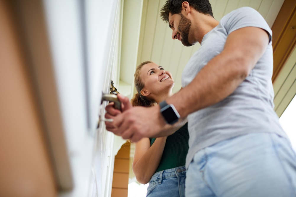 Ein Paar öffnet zusammen eine Tür.